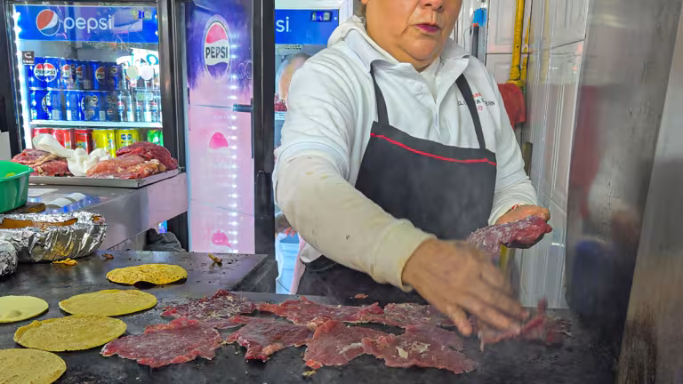 Kock vid stekbordet vid El Califa de León som steker kött.