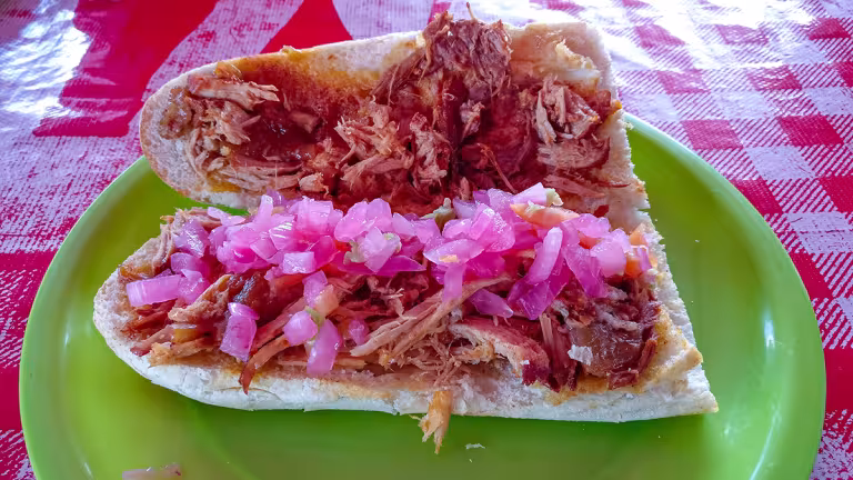 Torta de Cochinita Pibil med inlagd rödlök.